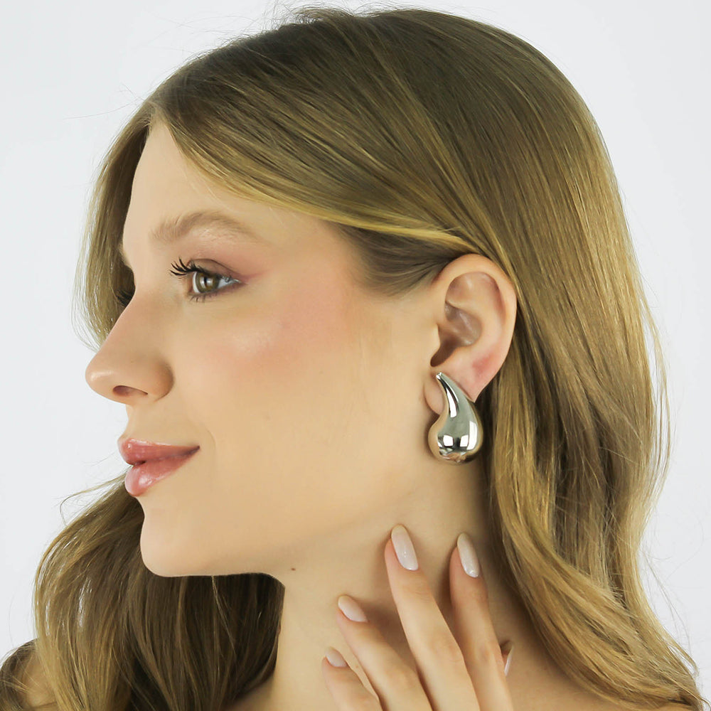 Brinco Virgula Ôndula com design curvo banhado a ouro da coleção Aura Alvorecer