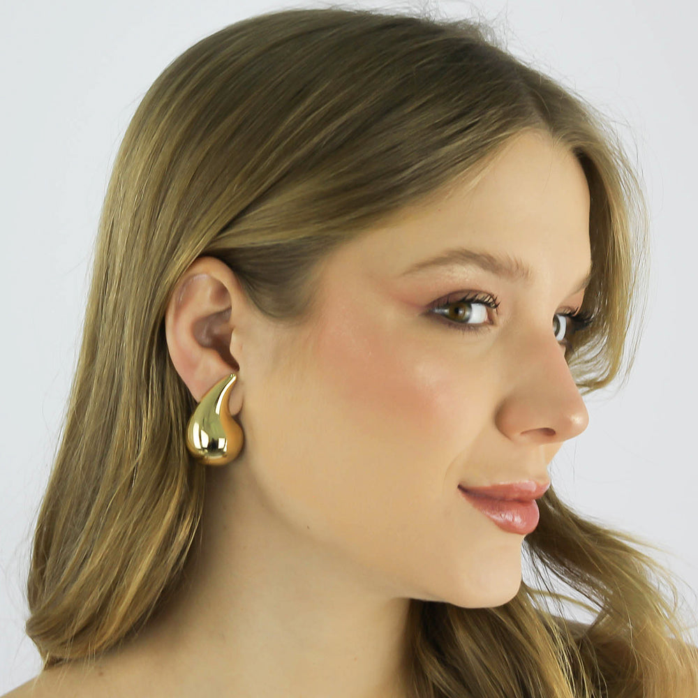 Brinco Virgula Ôndula com design curvo banhado a ouro da coleção Aura Alvorecer