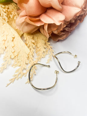 Brinco Argola Torcida Zênite com design torcido banhado a ouro da coleção Aura Alvorecer